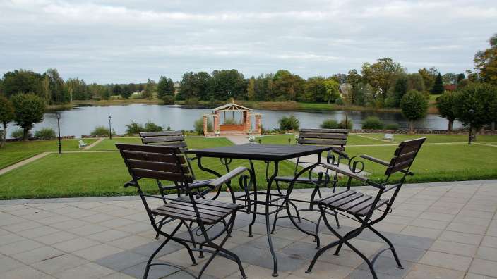 Ein Tisch und Stühle auf einer Terrasse mit Blick auf einen See