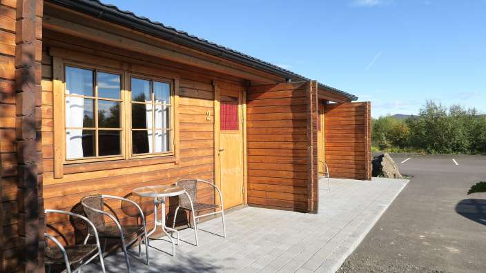 Eine Holzhütte mit einem Tisch und Stühlen vor der Tür