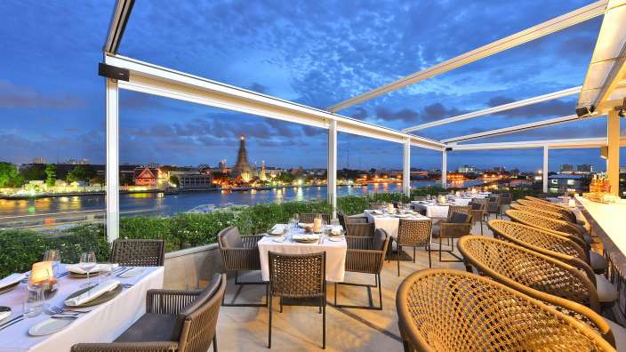 Tische und Stühle in einem Restaurant mit Blick auf den Fluss