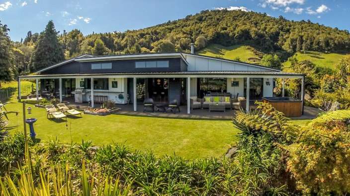 Ein großes Haus mit einer Veranda und einem Whirlpool im Garten