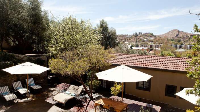 Eine Terrasse mit Tisch und Stühlen und Sonnenschirmen