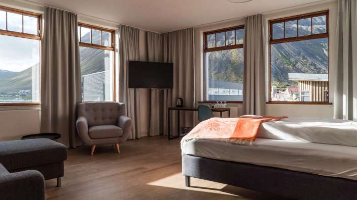 Ein Hotelzimmer mit einem Bett, einem Stuhl und einem Fernseher