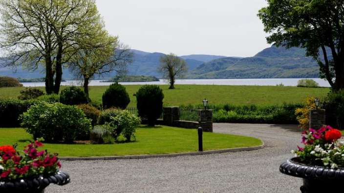 Ein Garten mit Blick auf einen See mit Bergen im Hintergrund