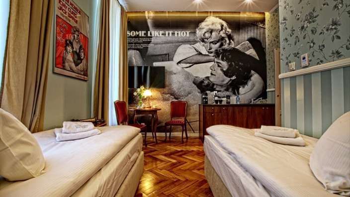 Ein Hotelzimmer mit zwei Betten und einem Poster an der Wand