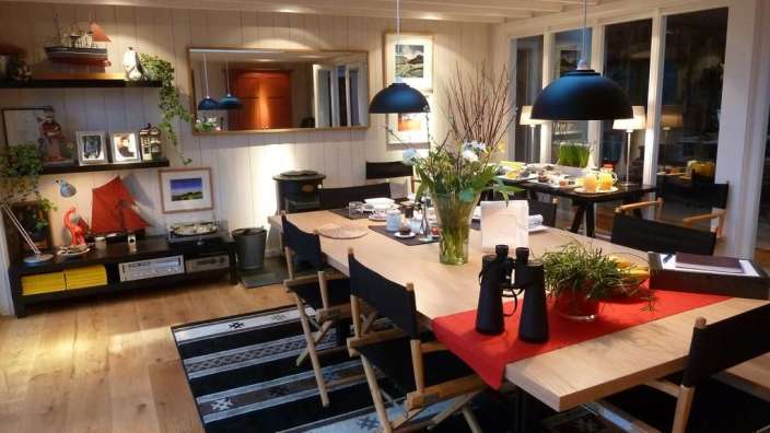 Ein Wohnzimmer mit einem Tisch und Stühlen und einem Spiegel