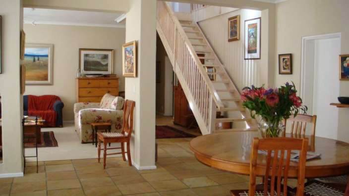 Ein Wohnzimmer mit einem Tisch und Stühlen und einer Treppe
