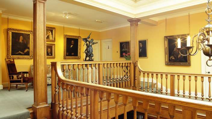 Eine Treppe in einem Haus mit Gemälden an den Wänden