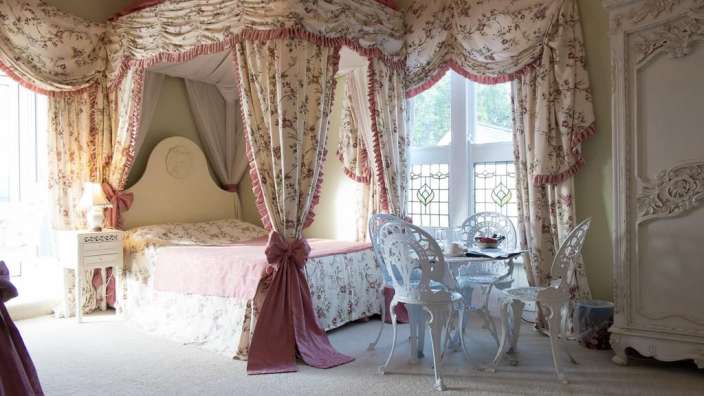 Ein Schlafzimmer mit einem Himmelbett und einem Tisch