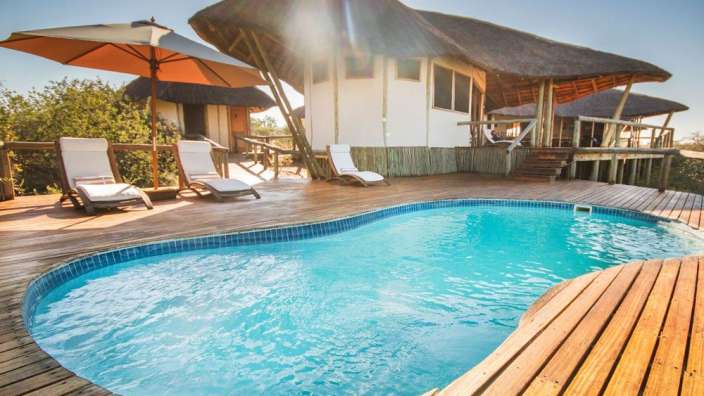 Ein großer Swimmingpool auf einem Holzdeck neben einem Haus