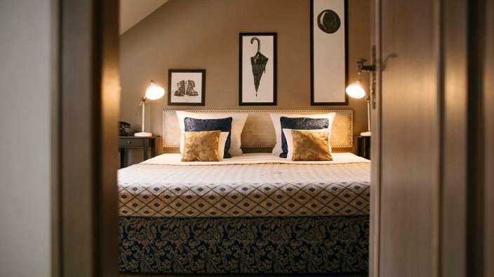 Ein Schlafzimmer mit einem Bett und drei Bildern an der Wand