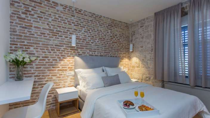 Ein Schlafzimmer mit einer Backsteinmauer und einem Bett