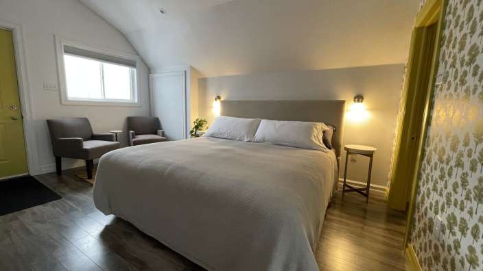 Ein Schlafzimmer mit einem Bett und zwei Stühlen