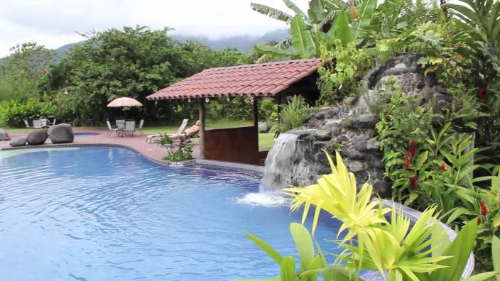 Ein Swimmingpool mit einem Wasserfall im Hintergrund