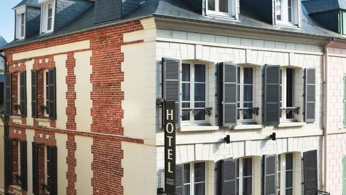 Ein Backsteingebäude mit vielen Fenstern und einem Hotelschild