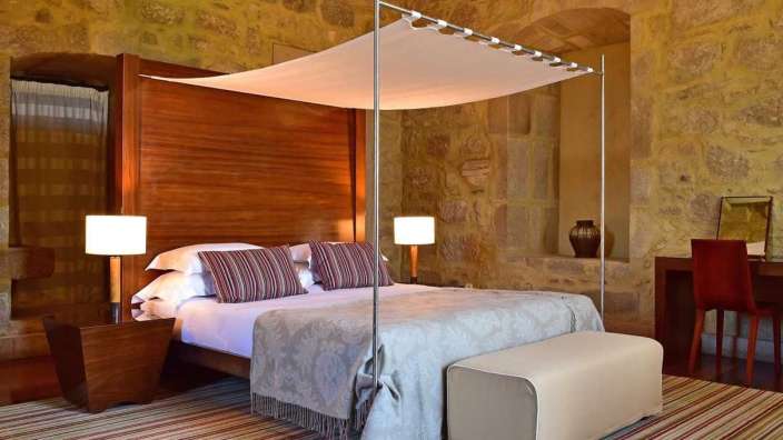 Ein Schlafzimmer mit einem Himmelbett und einem Stuhl