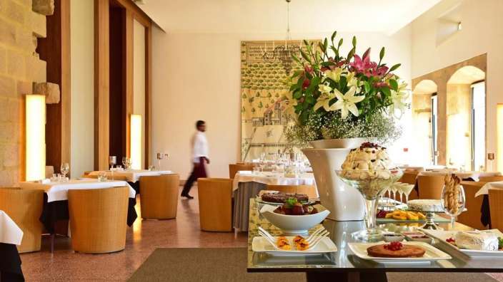 Ein Speisesaal mit vielen Tischen und einer Vase mit Blumen darauf