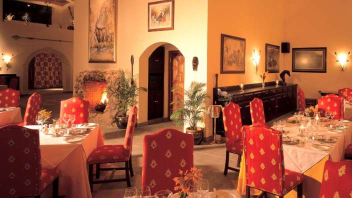 Ein Esszimmer mit Tischen und Stühlen und einem Kamin