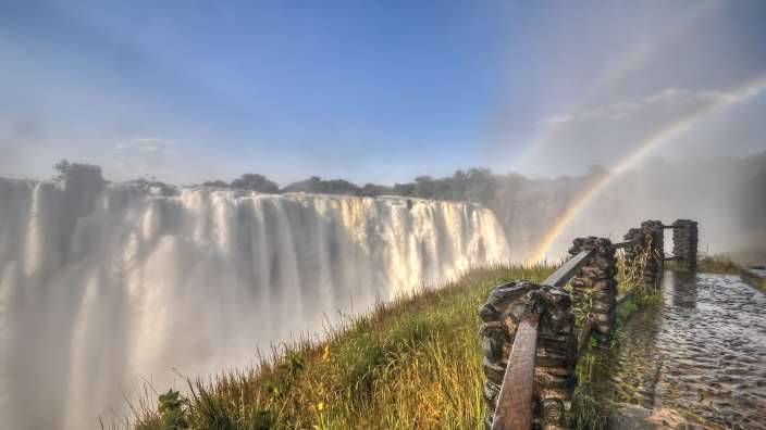 Ein Wasserfall mit einem Regenbogen in der Ferne