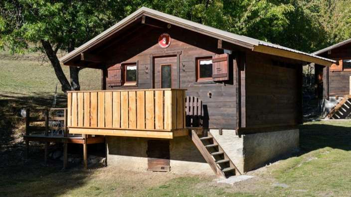 Ein kleines Holzhaus mit einem Balkon und einem Schild darauf