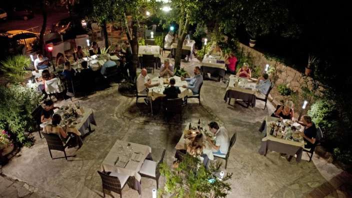 Eine Gruppe von Menschen sitzt an Tischen in einem Restaurant