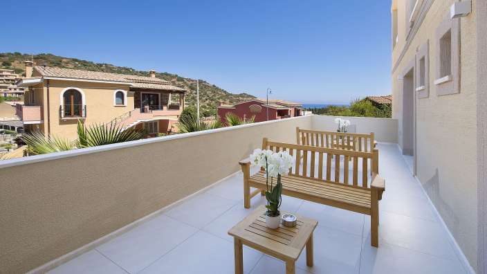 Ein Balkon mit einer Holzbank und einem Tisch