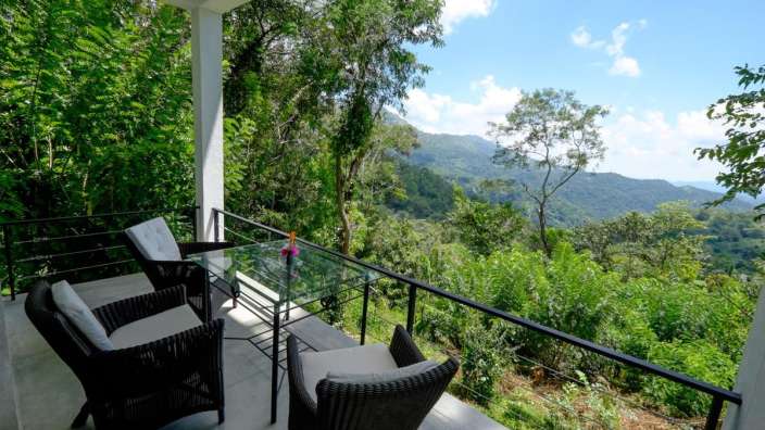 Zwei Stühle und ein Tisch auf einem Balkon mit Blick auf die Berge