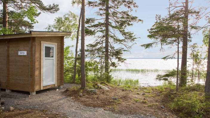 Ein Holzgebäude mit einem Schild darauf, das sauna sagt