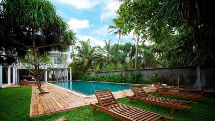 Liegestühle stehen neben einem großen Swimmingpool