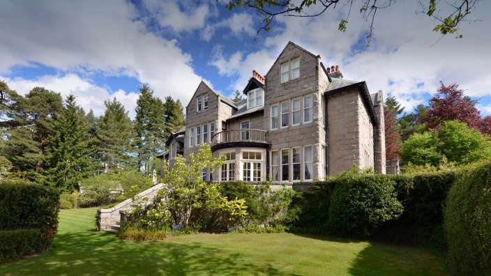 Ein großes Steinhaus mit vielen Fenstern und einem Balkon