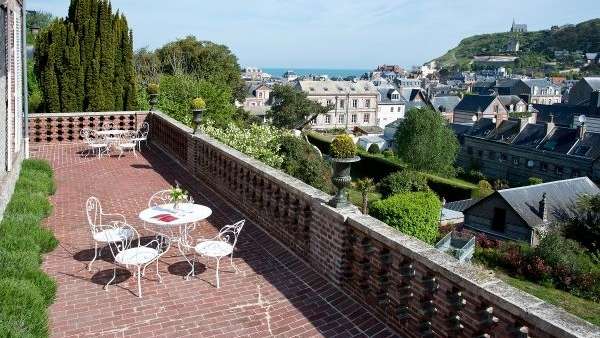 Ein Tisch und Stühle auf einem Balkon mit Blick auf eine Stadt