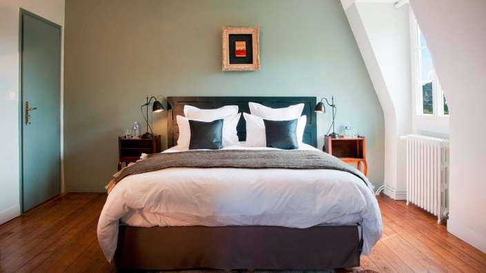 Ein Schlafzimmer mit einem Bett und einem Gemälde an der Wand