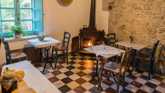 Ein Raum mit Tisch und Stühlen und einem Kamin