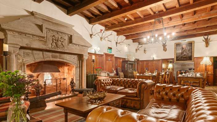 Ein Wohnzimmer mit Ledersofas und einem Kamin