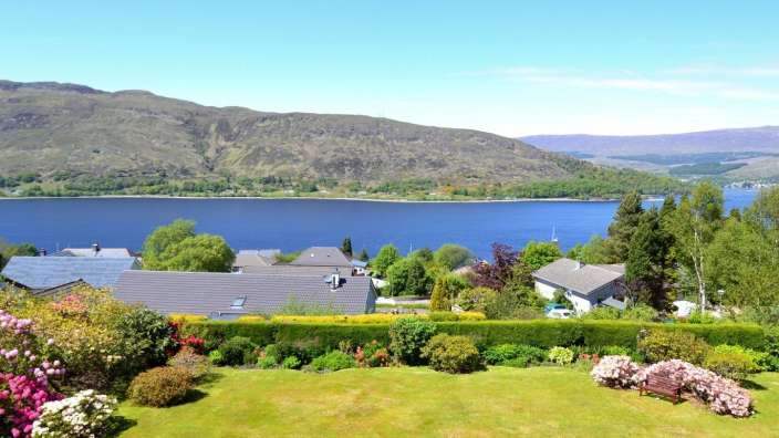 Ein Garten mit Blick auf einen See mit Bergen im Hintergrund