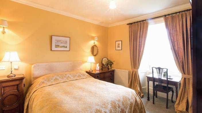 Ein Schlafzimmer mit einem Bett und einem Schreibtisch