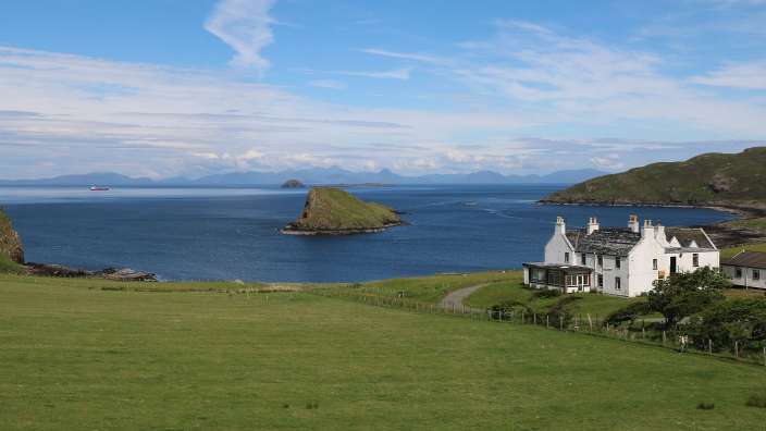 Ein weißes Haus steht auf einem Hügel mit Blick auf das Meer