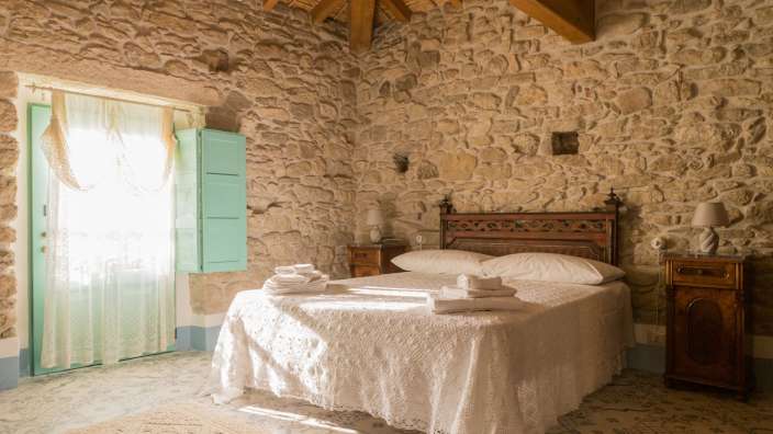 Ein Schlafzimmer mit Steinwänden und einem Bett