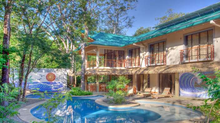 Ein großes Haus mit einem großen Swimmingpool davor