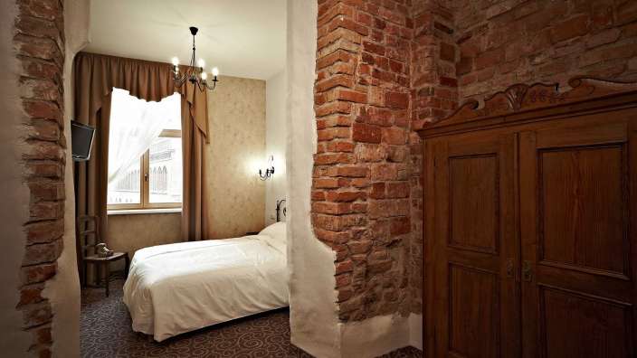 Ein Schlafzimmer mit einem Bett und einer Backsteinmauer