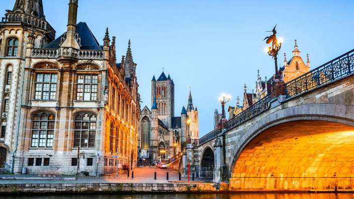 Eine Brücke über einen Fluss mit einem Gebäude im Hintergrund