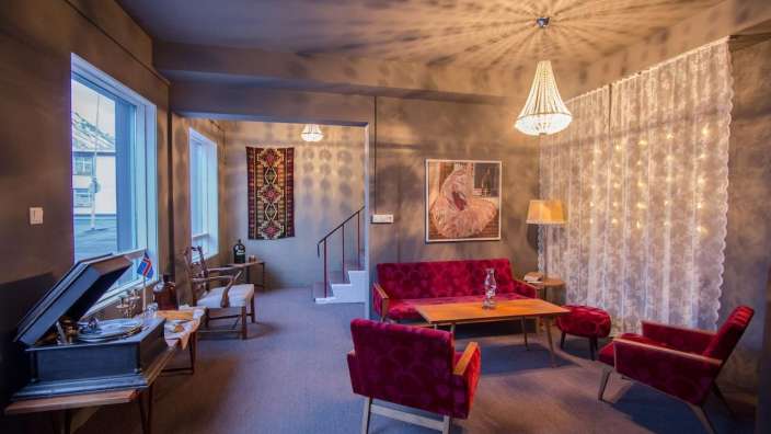 Ein Wohnzimmer mit roten Möbeln und einem Plattenspieler