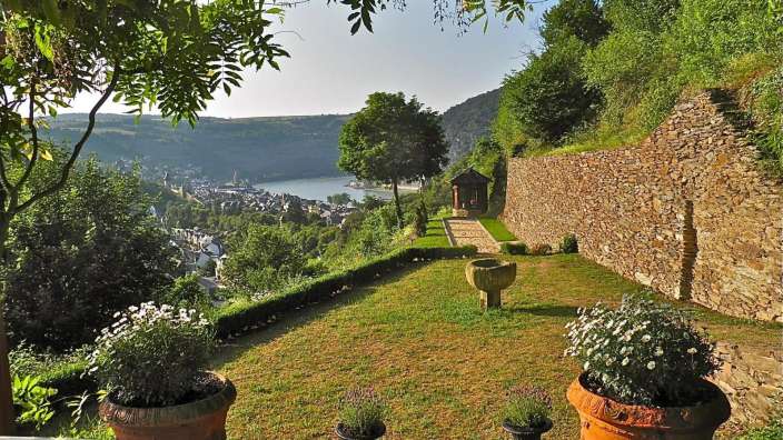 Ein Garten mit einer Steinmauer und einem Fluss im Hintergrund