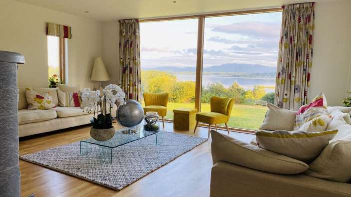 Ein Wohnzimmer mit vielen Möbeln und einem großen Fenster