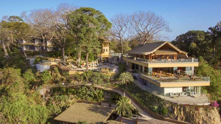 Ein großes Haus auf einem Hügel mit Bäumen umgeben