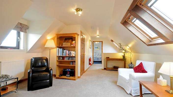 Ein Wohnzimmer mit einem schwarzen Stuhl und einem weißen Stuhl