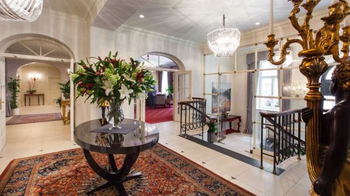 Ein Flur mit einem Tisch und einer Vase mit Blumen darauf