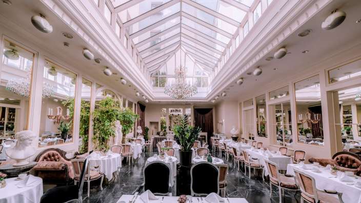 Ein großes Esszimmer mit vielen Tischen und Stühlen