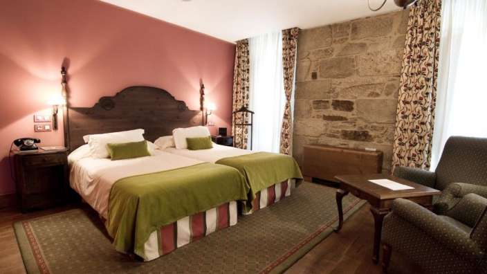 Ein Hotelzimmer mit zwei Betten und einem Stuhl