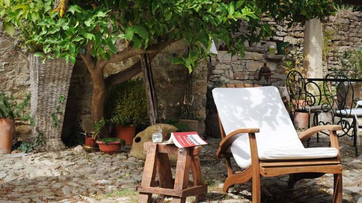 Ein weißer Stuhl mit einem Buch auf einem Holzhocker