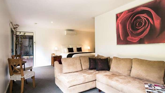 Ein Wohnzimmer mit einem Bild einer roten Rose an der Wand